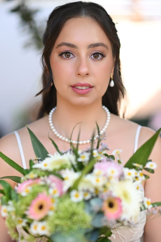 Bridal makeup and hairstyle for the bride. Light nude makeup with delicate eyeliner and a half-up hairstyle with soft waves — a gentle, romantic bridal look. Bridal Makeup Artist Maria Gorelova